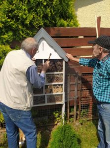 seniorzy Dziennego Domu wykonują domek dla owadów