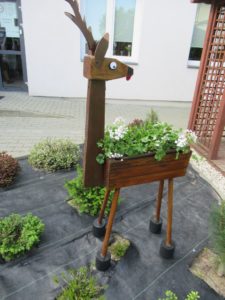 drewniana doniczka ogrodowa-jelonek znajdująca się w ogrodzie Dziennego Domu Pomocy w Jaśle