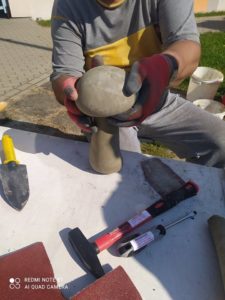 senior Dziennego Domu Pomocy składa poszczególne elementy grzyba z cementu