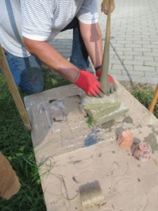 senior Dziennego Domu formuje z cementu odlew grzyba