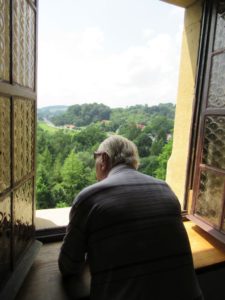 senior Dziennego Domu spogląda przez okno w Muzeum w Bieczu