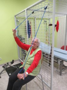seniorka Dziennego Domu Pomocy w Jaśle wykonuje ćwiczenia samowspomagane kończyn górnych