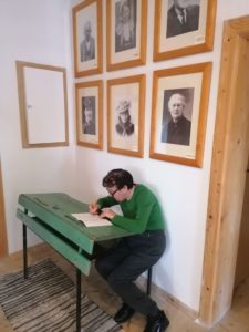 seniorka Dziennego Domu Pomocy wpisuje się do księgi pamiątkowej w Muzeum w Żarnowcu