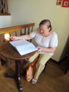 seniorka Dziennego Domu wpisuje się do księgi pamiątkowej w Muzeum w Bieczu