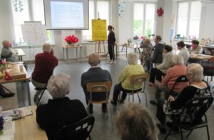 seniorzy Dziennego Domu Pomocy słuchają prelekcji promującej zdrowy styl życia