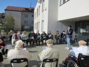 seniorzy Dziennego Domu Pomocy spędzają czas na świeżym powietrzu, śpiewając piosenki
