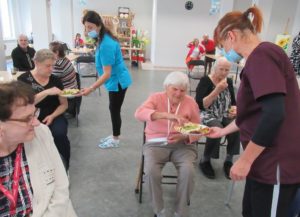 seniorzy Dziennego Domu częstują się owocami po zakończeniu prelekcji na temat zdrowego stylu życia