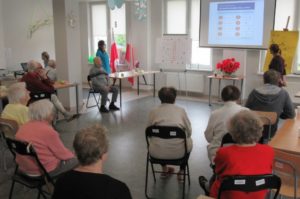 seniorzy słuchają prelekcji na temat zdrowego stylu życia w Dziennym Domu Pomocy