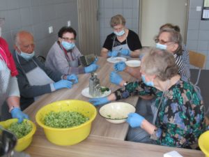 seniorzy, wspólnie z opiekunem przygotowują placuszki z cukini na zajęciach kulinarnych w Dziennym Domu Pomocy