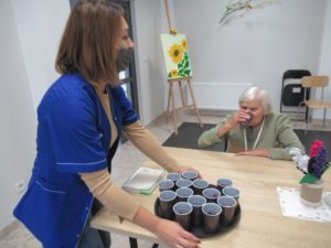 terapeuta zajęciowy częstuje seniorkę Dziennego Domu sokiem z kiszonych buraczków czerwonych