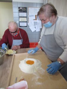 uczestnicy Dziennego Domu Pomocy w Jaśle przygotowują szarlotkę na zajęciach kulinarnych