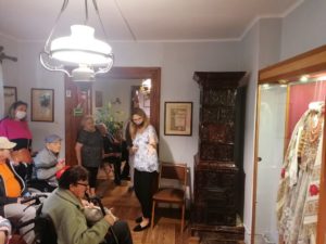 uczestnicy Dziennego Domu z opiekunką słuchają przewodnika w Muzeum w Żarnowcu