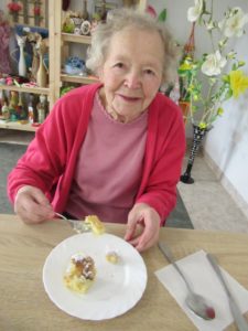 uczestniczka Dziennego Domu Pomocy w Jaśle je szarlotkę upieczoną przez seniorów na zajęciach kulinarnych