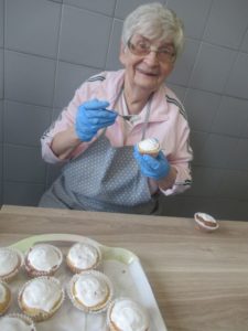 seniorka Dziennego Domu Pomocy przygotowuje babeczki w kuchni Dziennego Domu