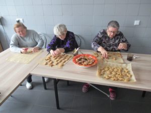 seniorki Dziennego Domu dekorują lukrem pierniczki na zajęciach kulinarnych