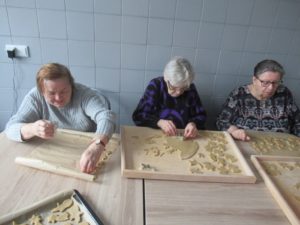 seniorki Dziennego Domu wykrawają foremką pierniczki z przygotowanego przez nie ciasta w kuchni Dziennego Domu