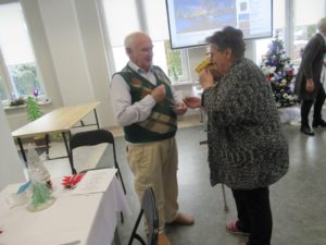 seniorzy Dziennego Domu Pomocy składają sobie życzenia podczas Spotkania wigilijnego