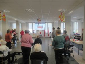 seniorzy śpiewają hymn państwowy podczas obchodów Święta Odzyskania przez Polskę Niepodległości