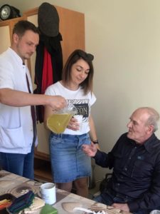 pracownicy Dziennego Domu Pomocy w Jaśle częstują podopiecznego syropem z mniszka lekarskiego