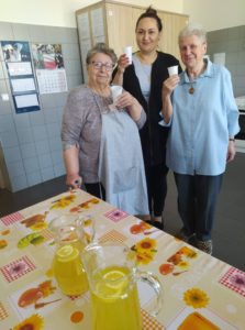 pracownik Dziennego Domu Pomocy w Jaśle wspólnie z seniorkami próbują syrop z mniszka lekarskiego