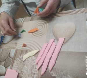 senior Dziennego Domu Pomocy dla Osób Starszych w Jaśle składa papierowe elementy origami