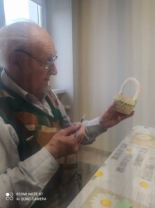 senior Dziennego Domu Pomocy w Jaśle przygotowuje koszyczek metodą origami