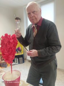 senior Dziennego Domu przygotowuje dekorację na Walentynki, na zajęciach terapii zajęciowej