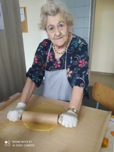 seniorka Dziennego Domu Pomocy przygotowuje ciasto na zajęciach kulinarnych