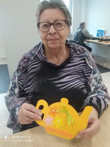 seniorka Dziennego Domu Pomocy w Jaśle prezentuje laurkę z życzeniami z okazji Dnia Babci i Dziadka