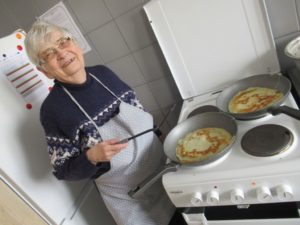 seniorka Dziennego Domu Pomocy w Jaśle smaży naleśniki na zajęciach kulinarnych