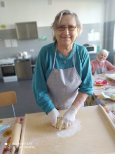 seniorka Dziennego Domu przygotowuje na zajęciach kulinarnych ciasto na kruche ciasteczka