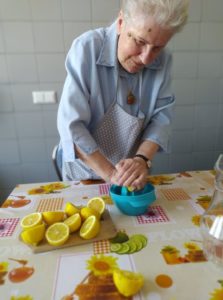 seniorka wyciska sok z cytryny w kuchni Dziennego Domu Pomocy w Jaśle, podczas przygotowywania syropu z mniszka lekarskiego