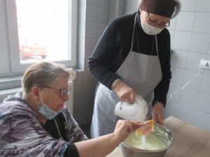seniorki Dziennego Domu Pomocy przygotowują ciasto na naleśniki na zajęciach kulinarnych