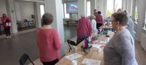 seniorzy Dziennego Domu Pomocy w Jaśle wspólnie z opiekunem przygotowywują się do odśpiewania hymnu państwowego