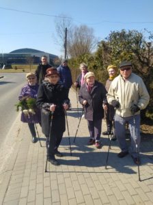 seniorzy Dziennego Domu Pomocy wspólnie z opiekunem spacerują w pierwszy dzień wiosny