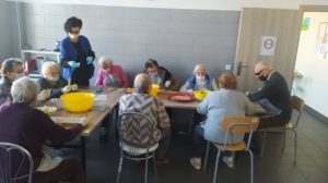 seniorzy Dziennego Domu przygotowują owocowe szaszłyki na zajęciach kulinarnych