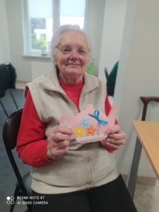 uczestniczka Dziennego Domu Pomocy prezentuje laurkę z życzeniami z okazji Dnia babci i Dziadka