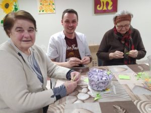 uczestniczki Dziennego Domu Pomocy w Jaśle, wspólnie z opiekunem przygotowują papierowe elementy origami