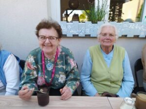 seniorki Dziennego Domu Pomocy w Jaśle piją kawę, spędzając czas na świeżym powietrzu
