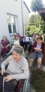 seniorzy Dziennego Domu Pomocy w Jaśle ćwiczą pamięć tworząc anagramy, pdczas wspólnych zajęć na świeżym powietrzu
