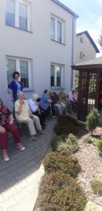 seniorzy Dziennego Domu Pomocy w Jaśle wpólnie z opiekunem uczestniczą w zabawie Głuchy telefon