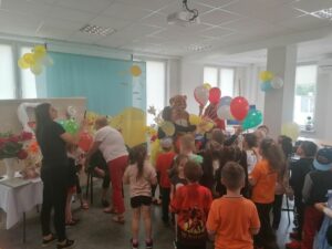 zaproszone do Dziennego Domu Pomocy w Jaśle dzieci otrzymują kolorowe balony z okazji Dnia Dziecka